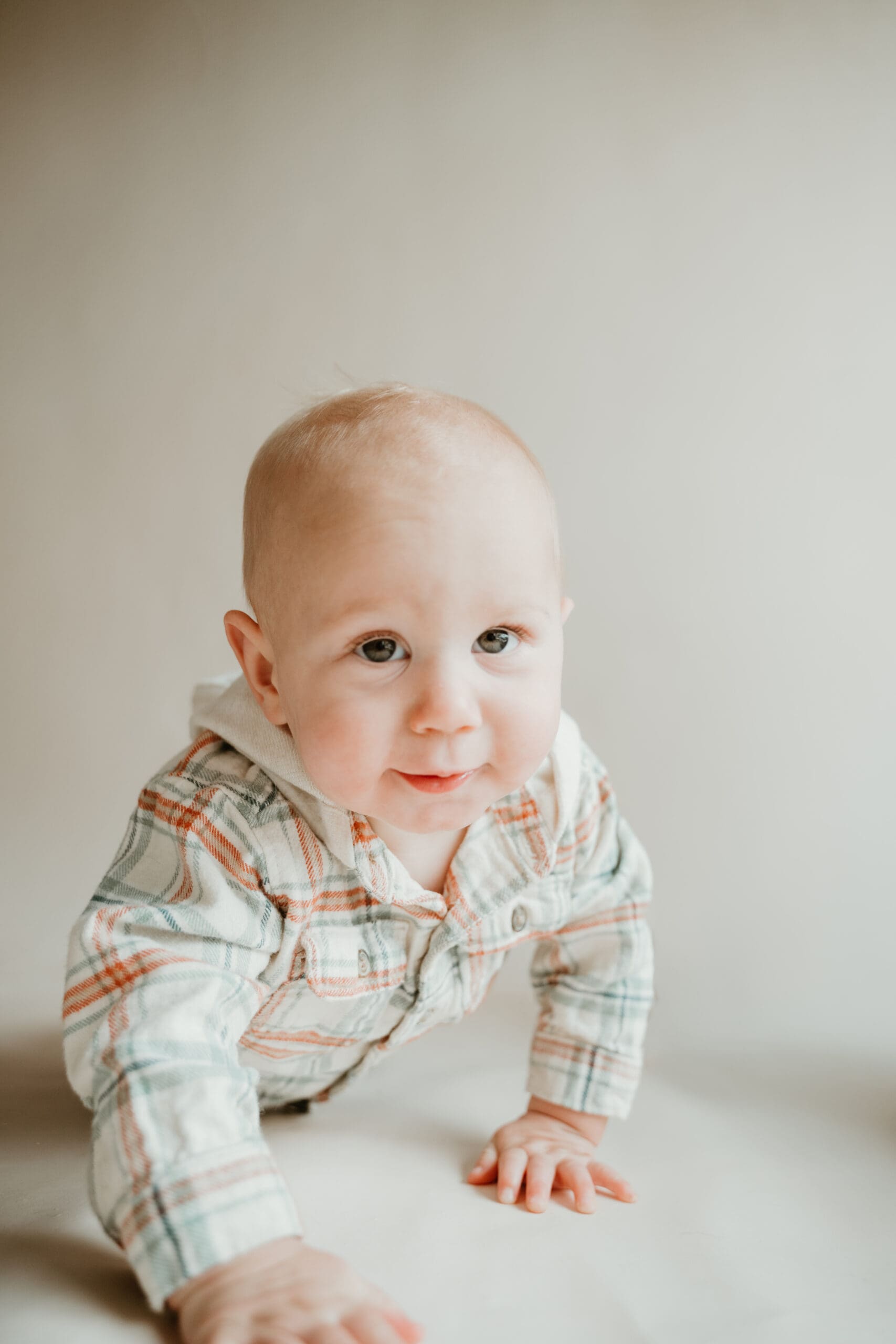 Image of a small infant boy crawling towards the camera.
